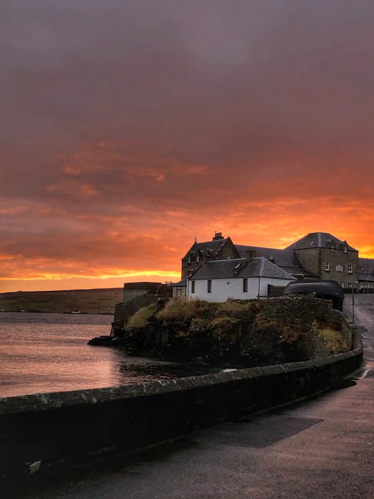 white and gray concrete building near body of water during sunset in Lerwick United Kingdom