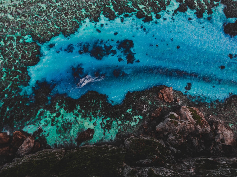 aerial view of ocean waves crashing on rocks