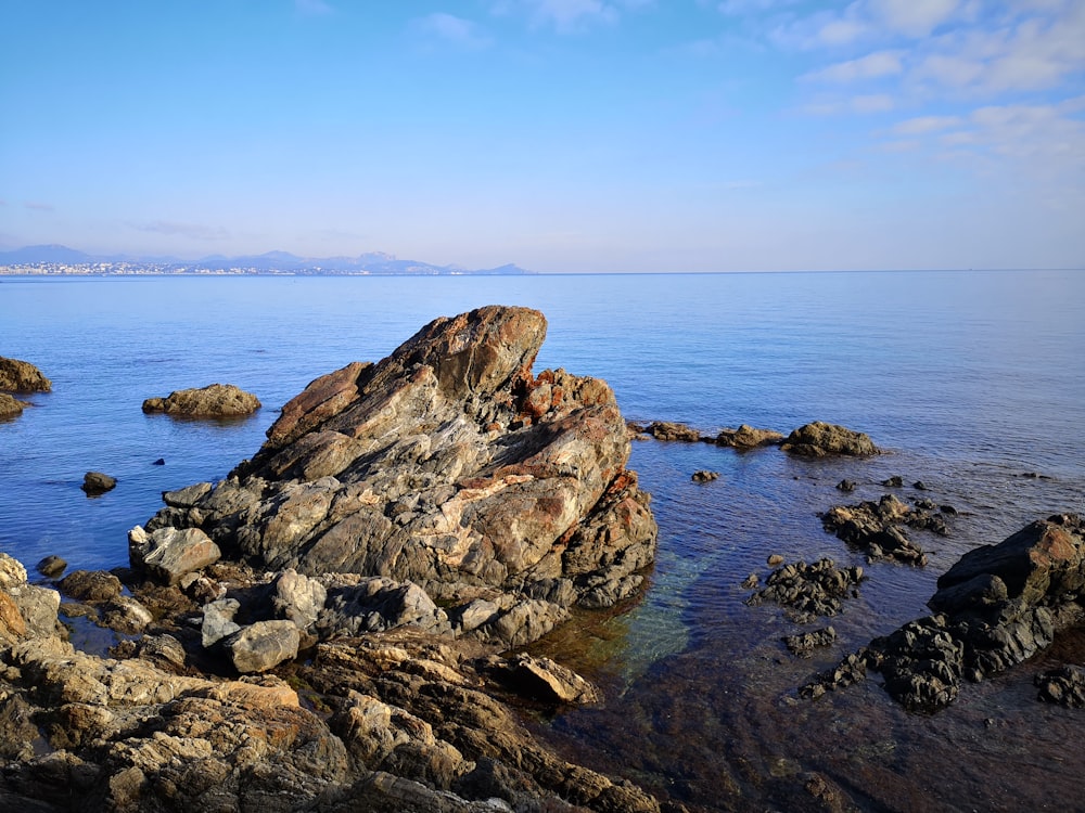 brown rock formation on sea during daytime