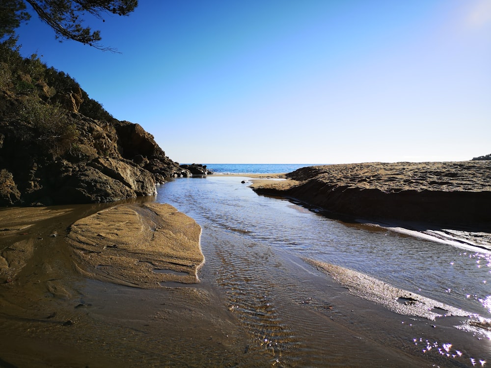 Formación rocosa marrón en la orilla del mar durante el día