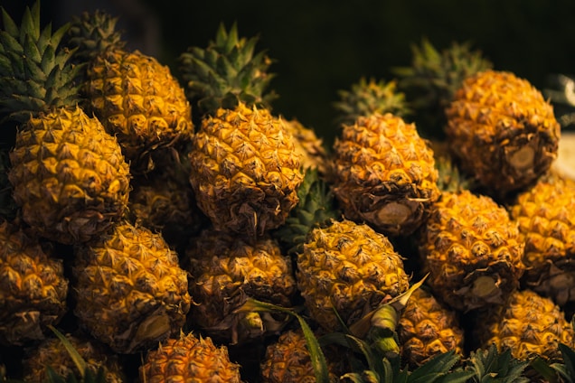 A vibrant display of fresh pineapples in an orange-themed setting.