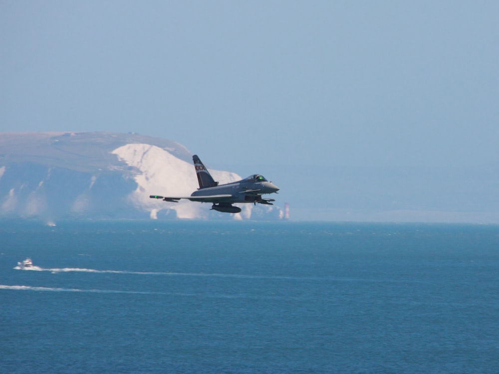 white and black jet plane flying over the sea during daytime