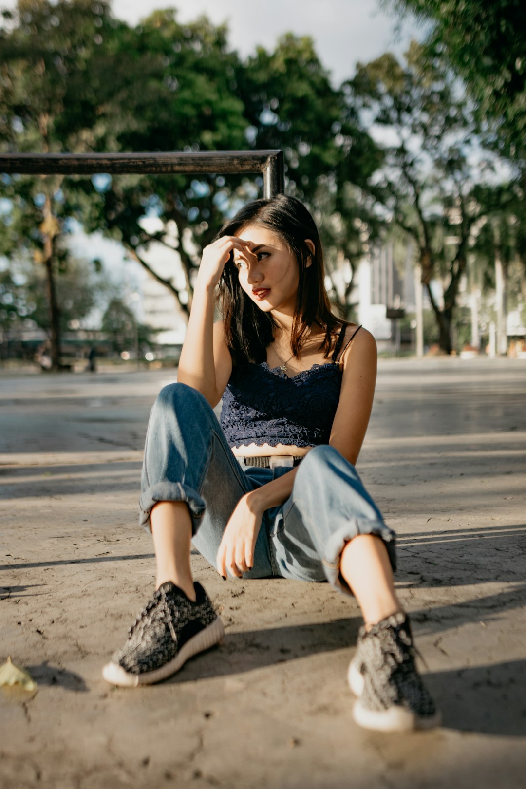 woman in black tank top and blue denim shorts sitting on brown wooden bench during daytime