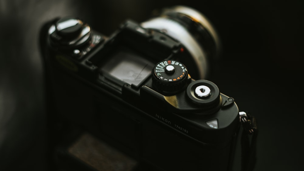 black dslr camera on brown wooden table