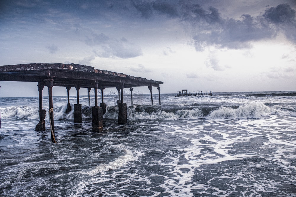 brown wooden dock on sea under white clouds during daytime