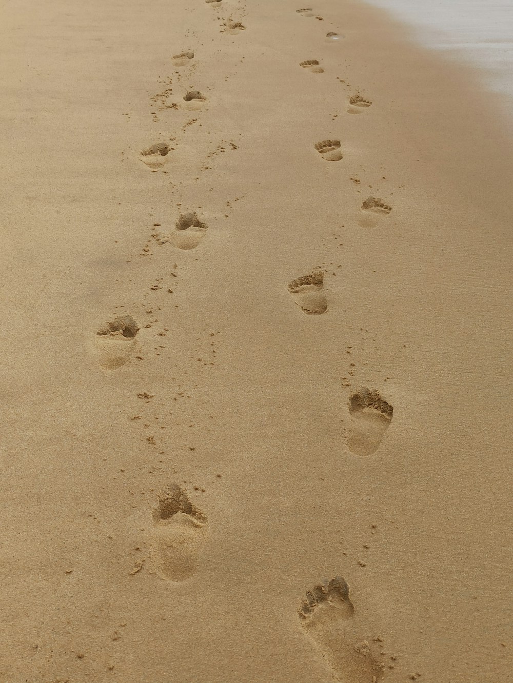 empreintes de pas sur le sable pendant la journée