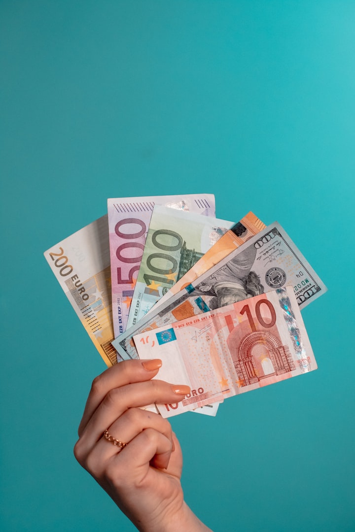 Hand hält Dollar und Euro Geldscheine vor grünem Hintergrund