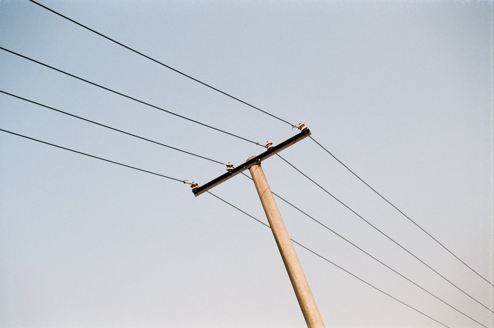 brown electric post under blue sky during daytime