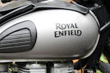 Close-up of the iconic Royal Enfield logo on a gleaming fuel tank.