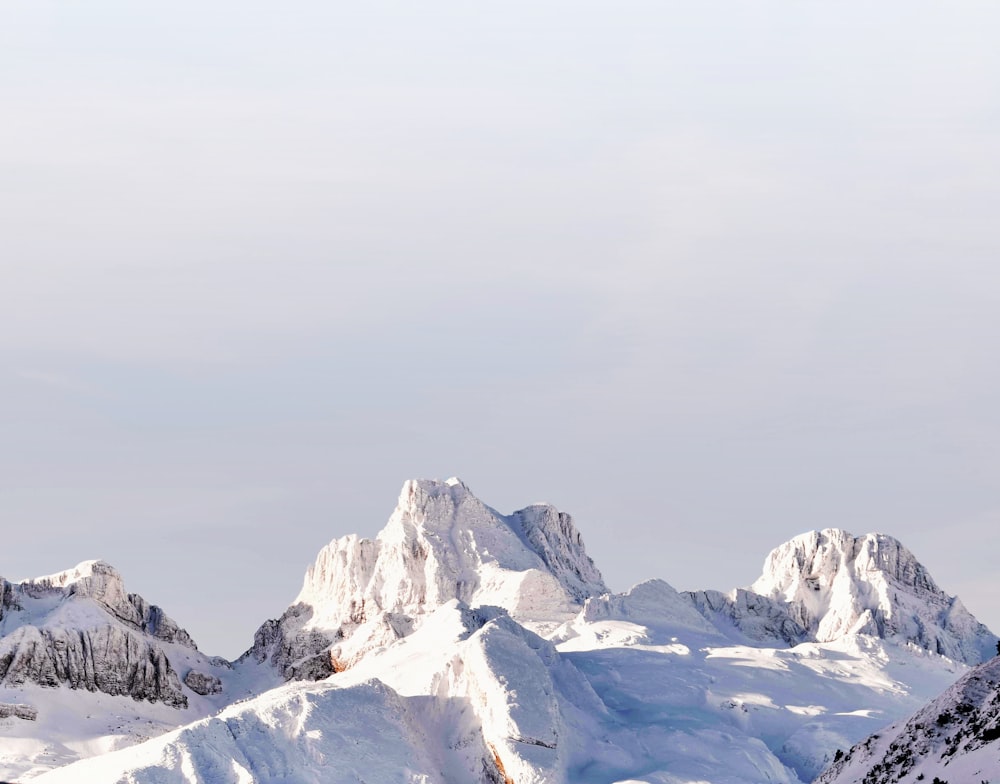 montagne coperte di neve sotto il cielo grigio