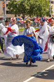 A lively group dancing traditional Portuguese folk dances in colorful attire during a community festival.