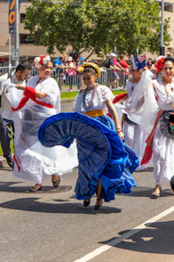A lively group dancing traditional Portuguese folk dances in colorful attire during a community festival.
