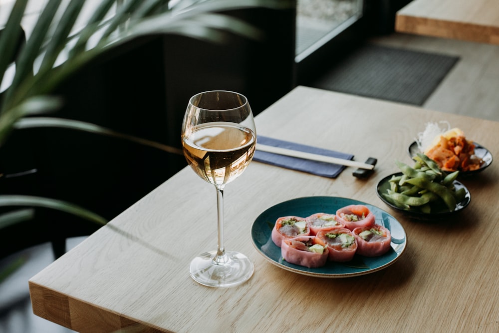 un plato de comida y una copa de vino sobre una mesa