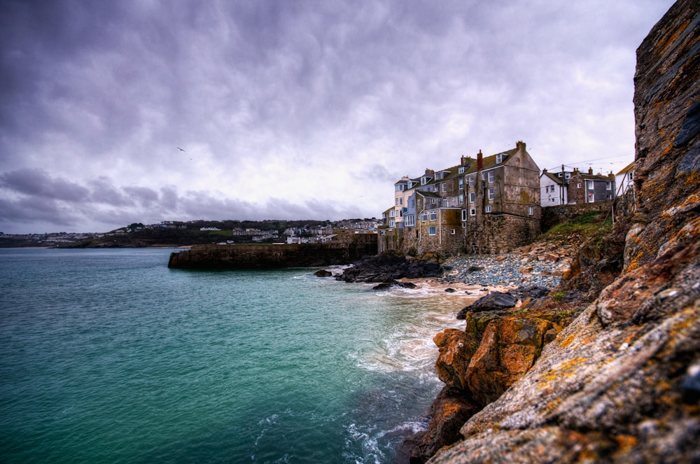 brown concrete building near sea under cloudy sky during daytime