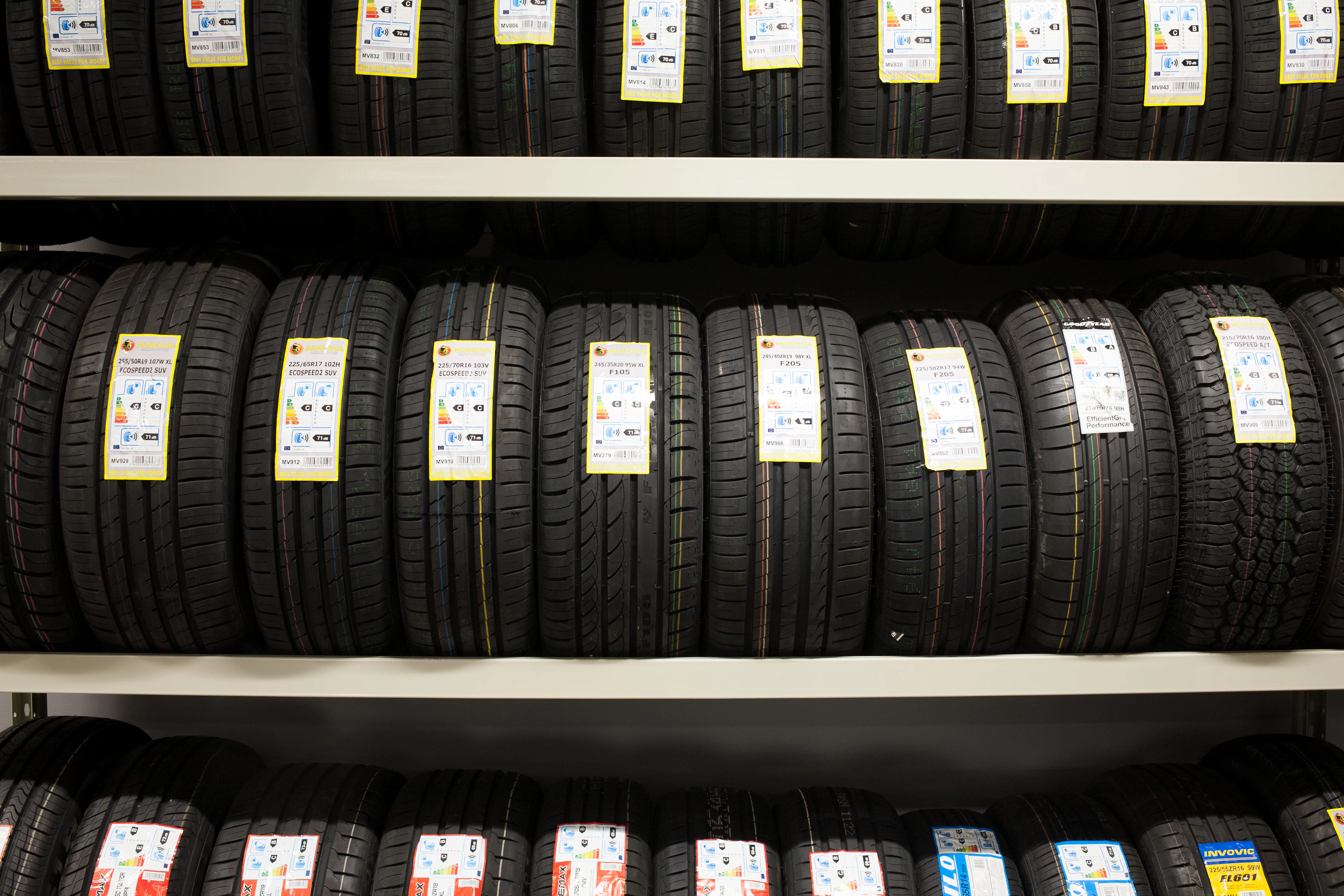 New tires on a shop rack with tread labels