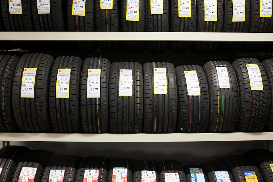 Rows of new tires on retail shelves with paper price tags attached