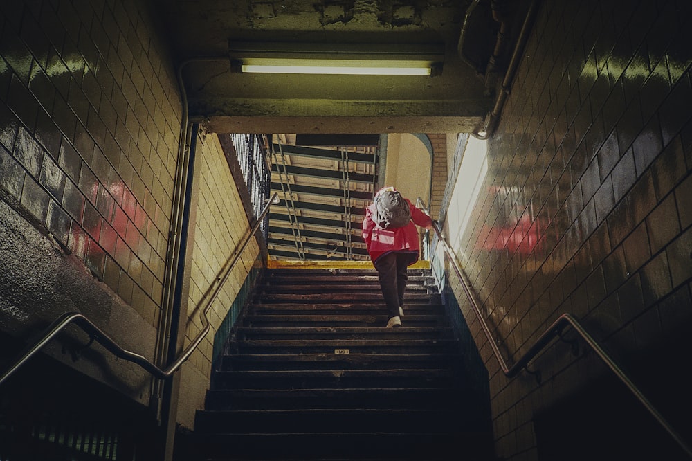 person in red shirt walking down the stairs