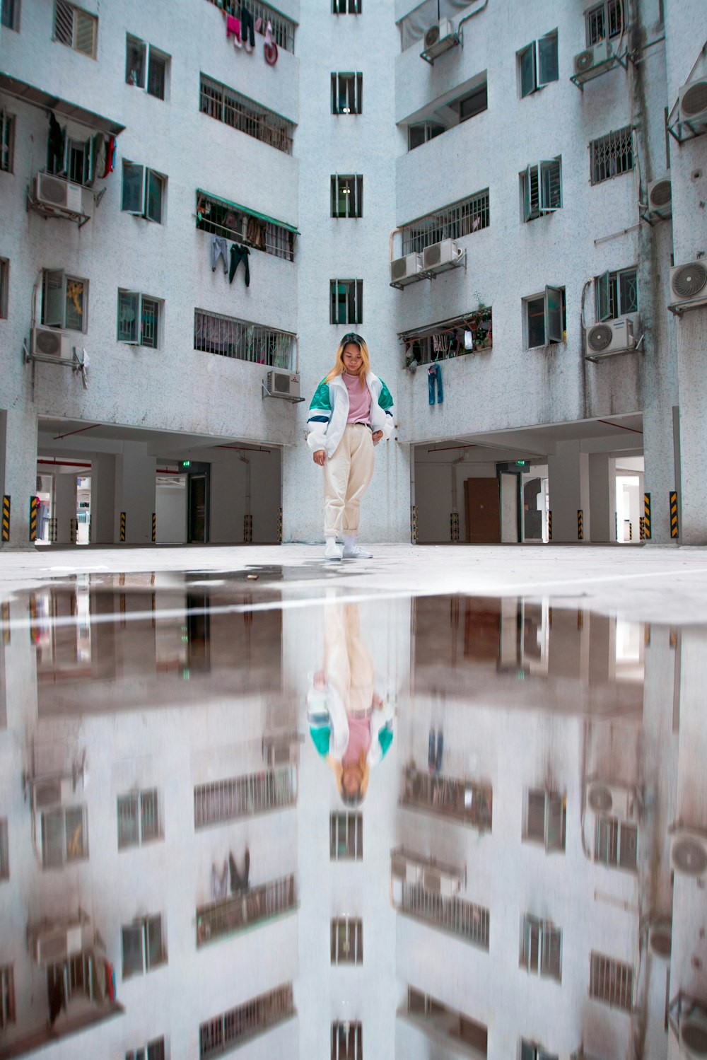 woman in white shirt and black pants standing on white floor