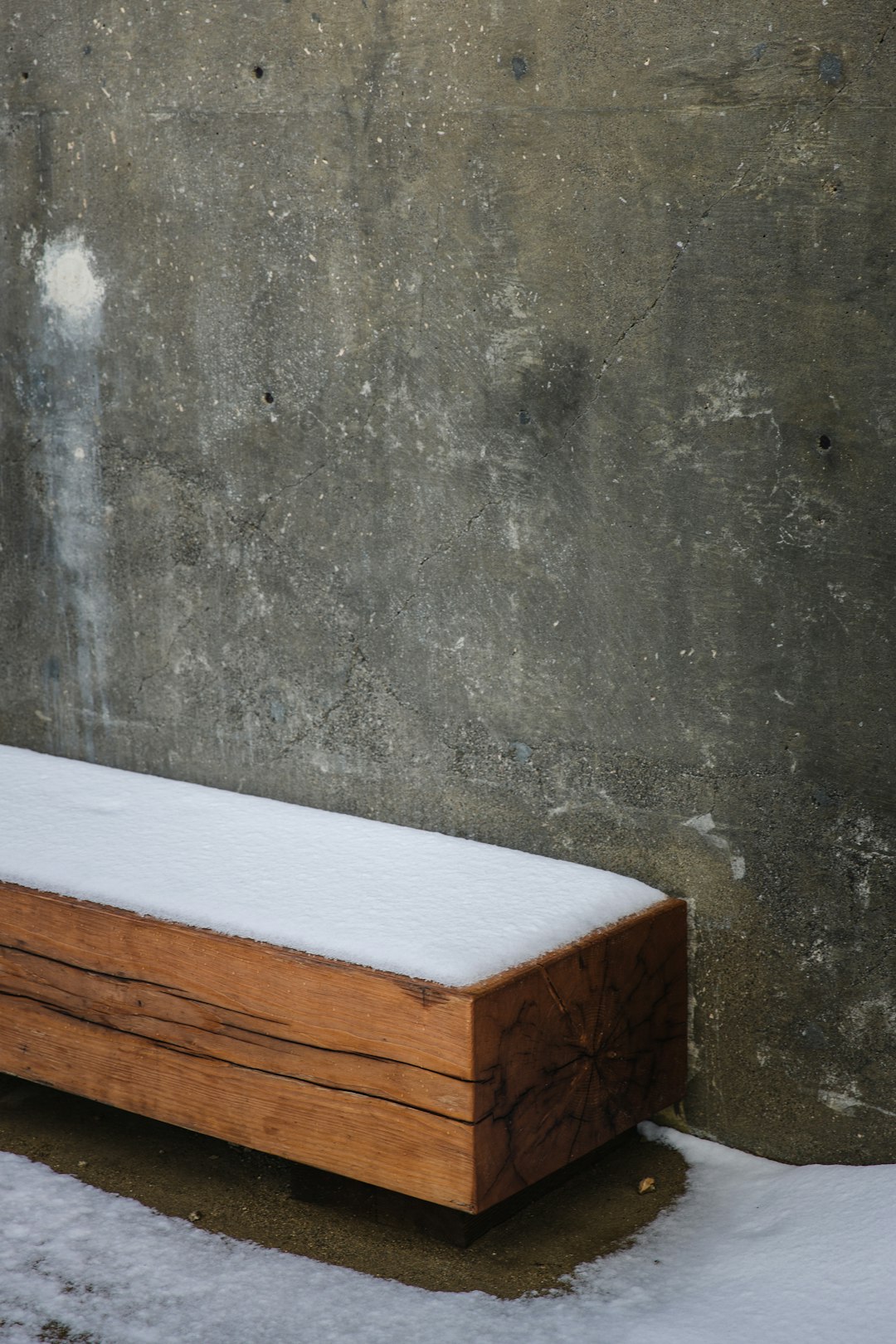 brown wooden table beside gray concrete wall