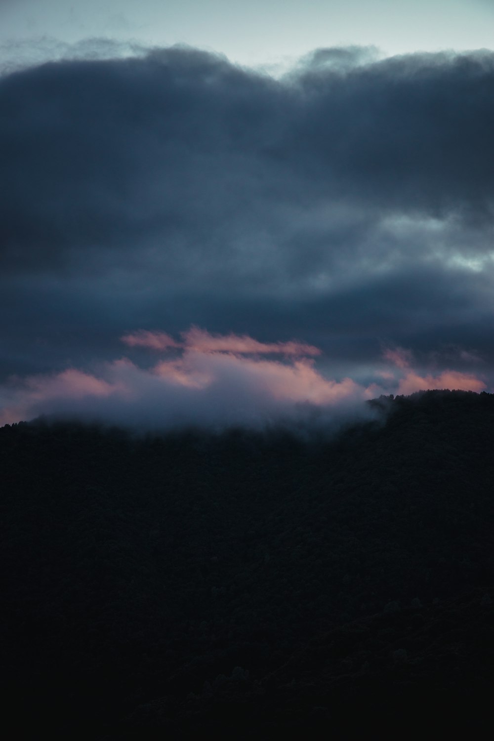 a dark sky with a few clouds in the distance