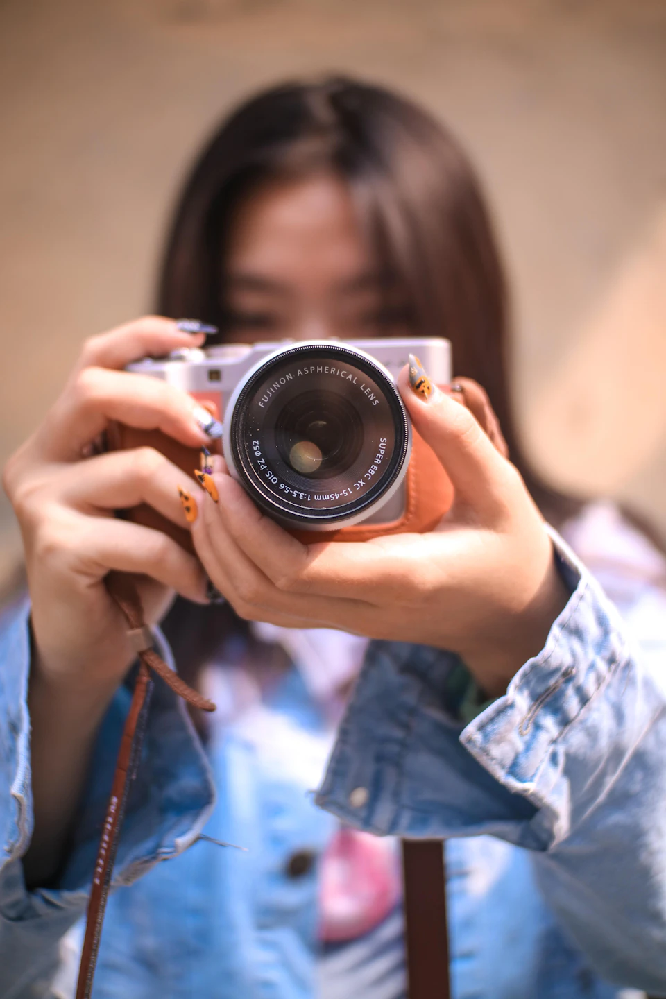 Person holding camera with both hands, looking through lens with left hand supporting it
