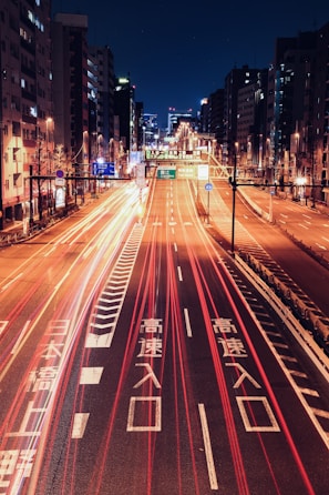 Nighttime shot of Kouki Enterprises vehicle on a highway with city lights in the background.