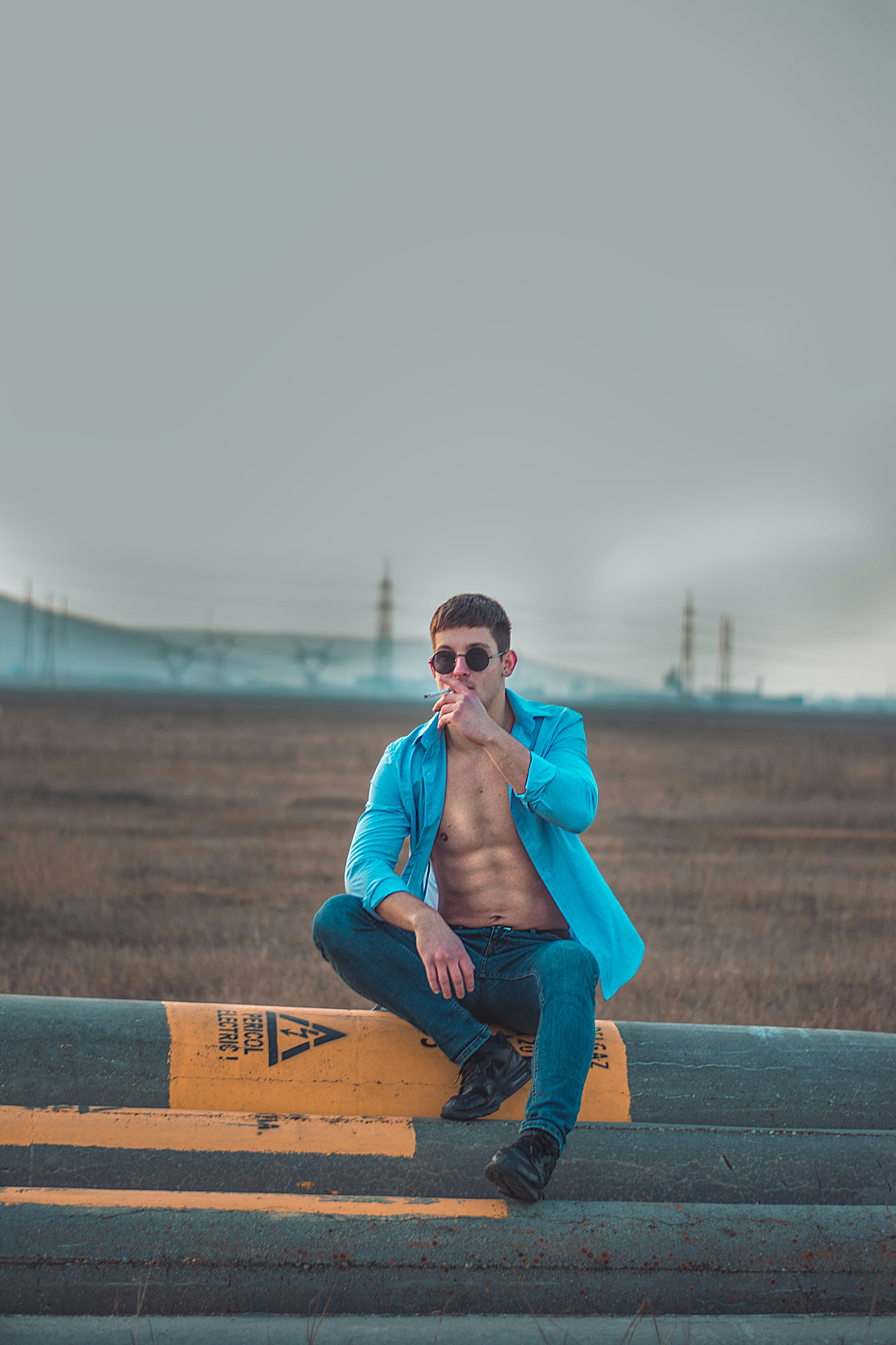 Man In Orange Dress Shirt And Blue Denim Jeans Sitting On Brown