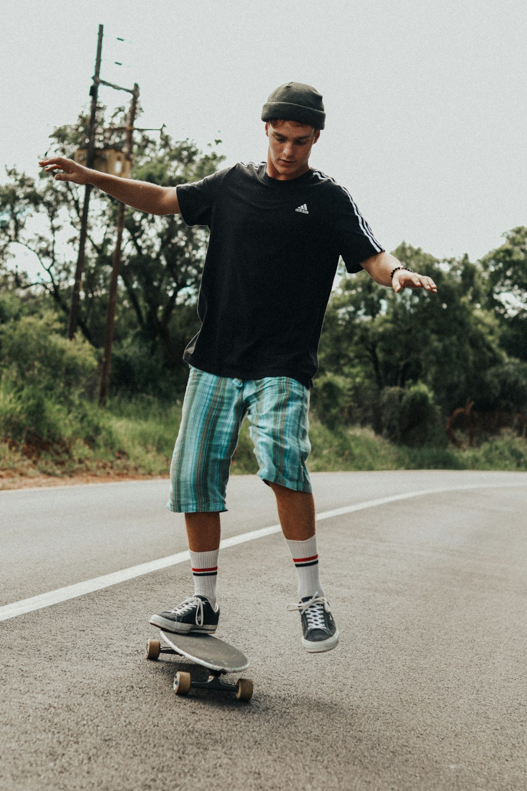 man in black crew neck t-shirt and green shorts running on road during daytime