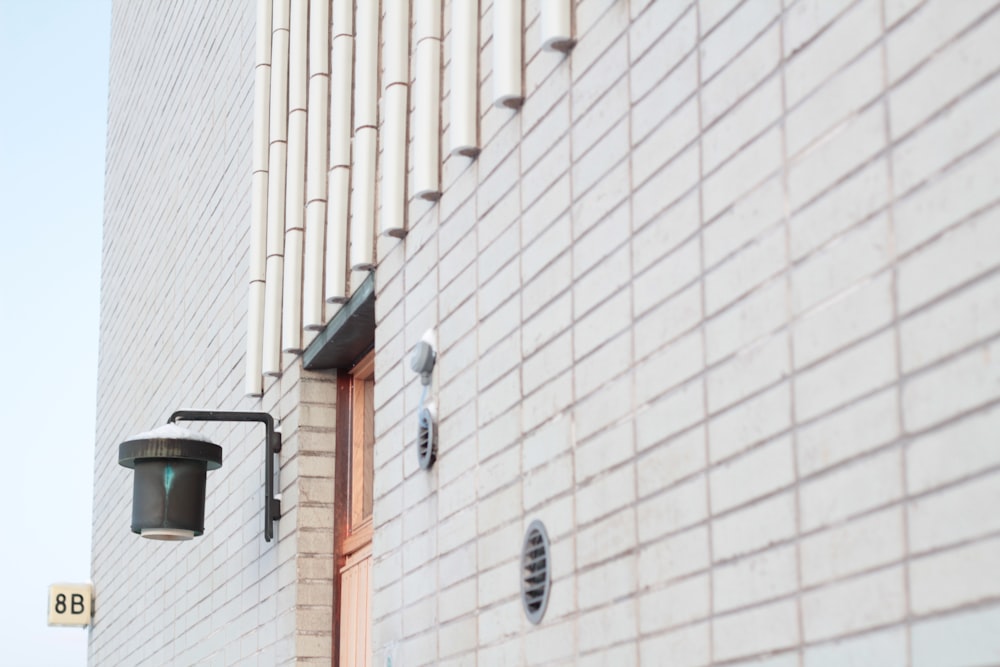 black outdoor sconce on white brick wall