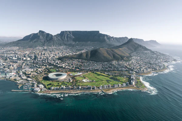 Aerial view of a coastal city on a peninsula with a flat-topped mountain behind it