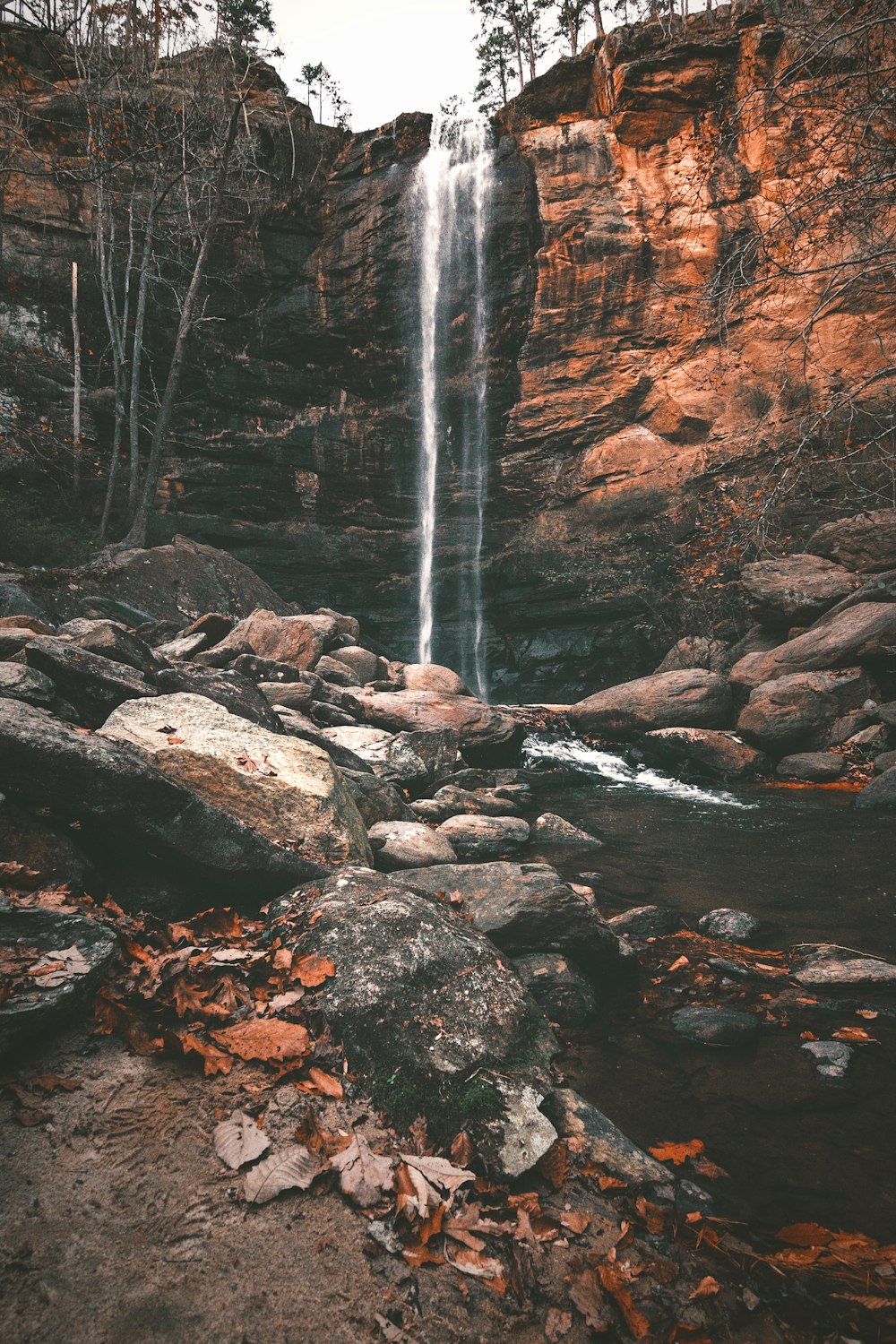 water falls on brown rocky mountain