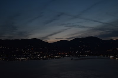 city skyline near body of water during night time