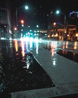 A photo showing the contrast of a wet street with reflections of city lights after rain.