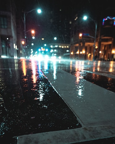 A photo showing the contrast of a wet street with reflections of city lights after rain.