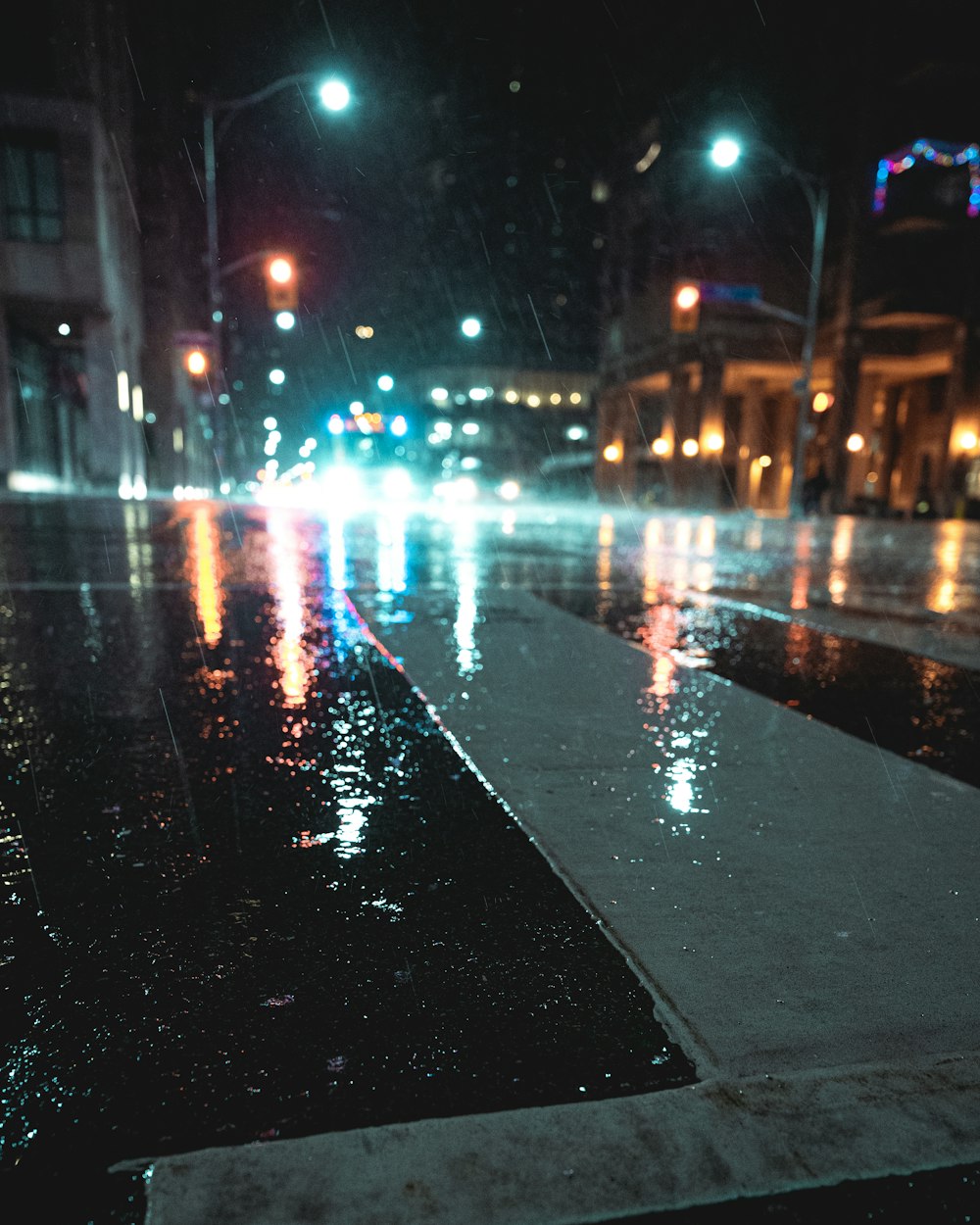 strada asfaltata nera con auto durante la notte