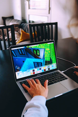 person using macbook pro on black table