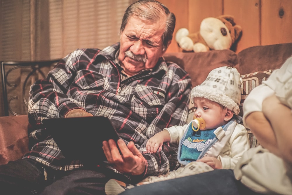 man in plaid shirt holding baby