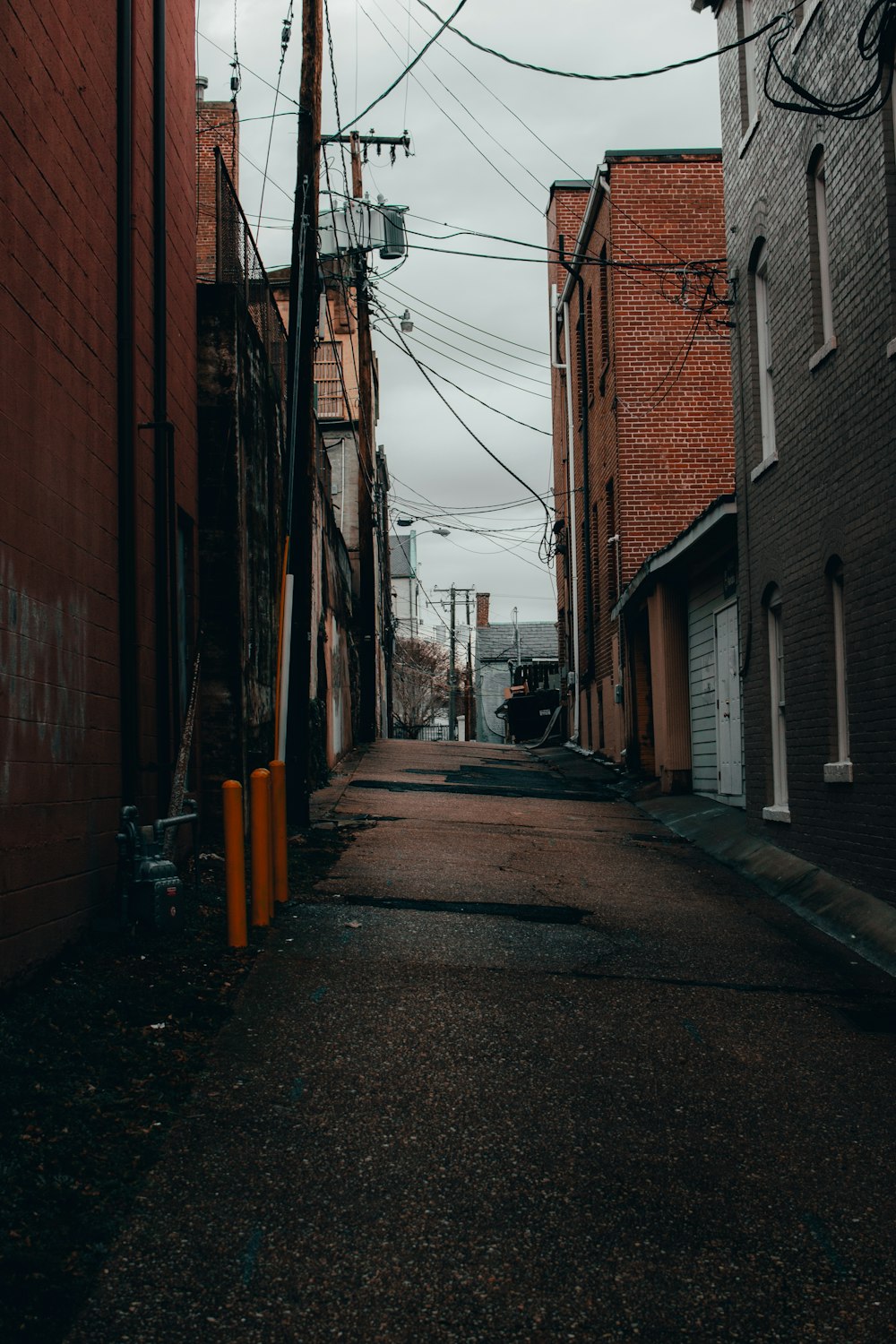 empty street between brown brick buildings during daytime