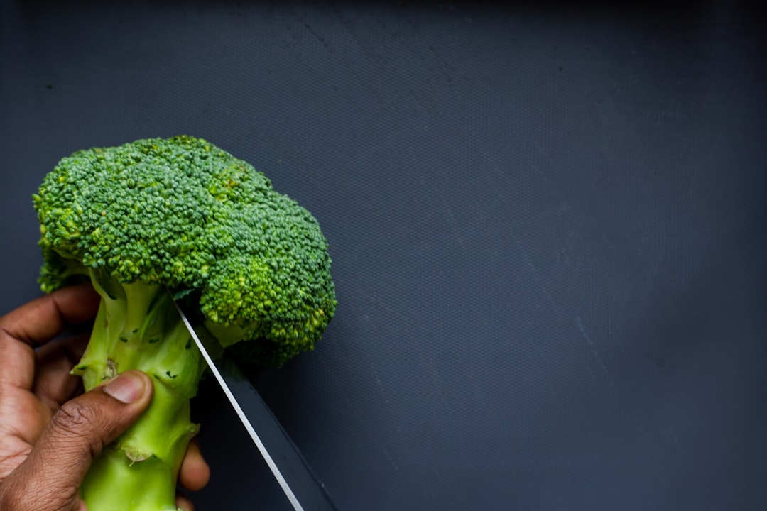 person holding green broccoli vegetable