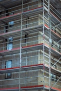 Steel scaffolding set up around a multi-story building under renovation.