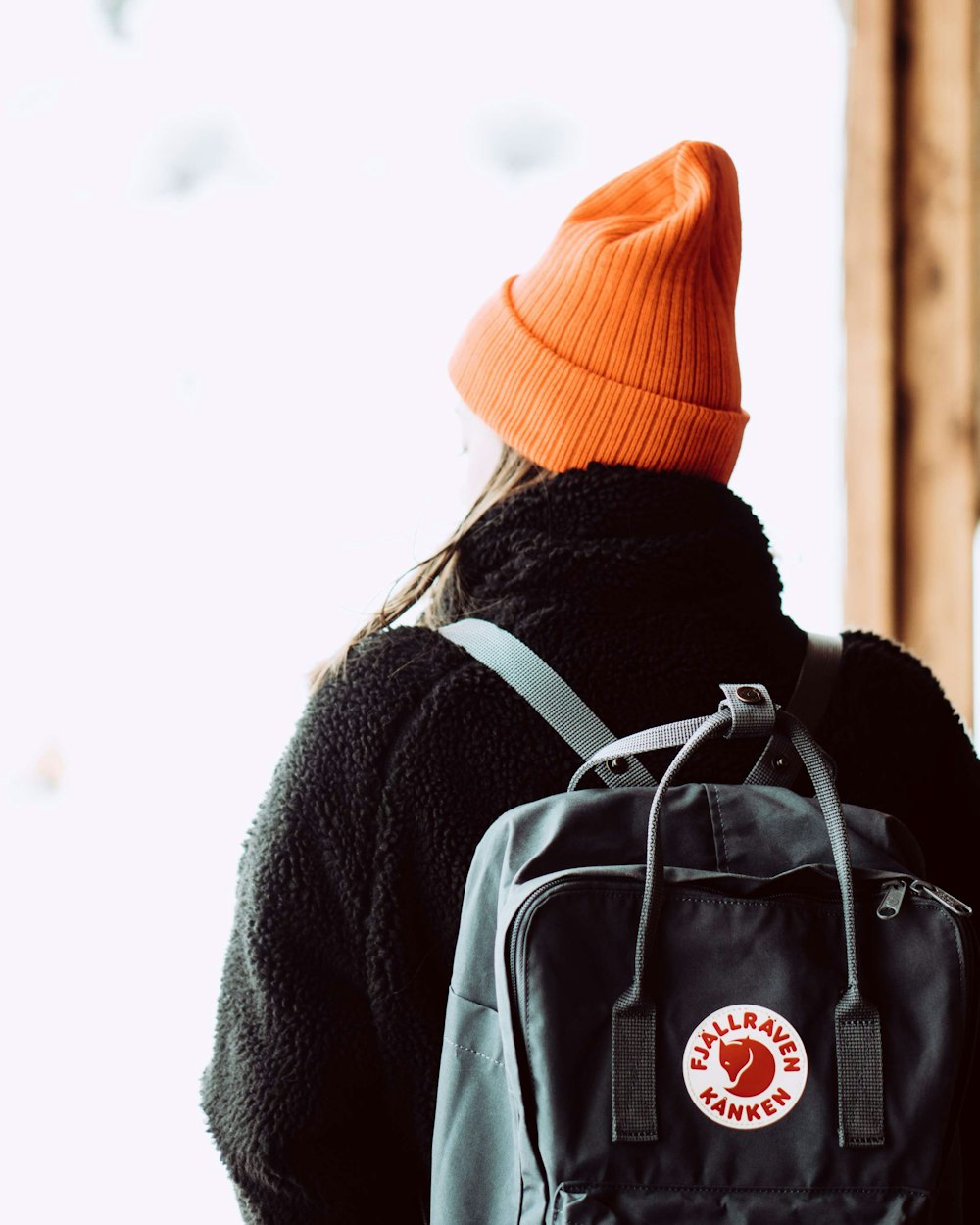 person in gray coat and orange knit cap