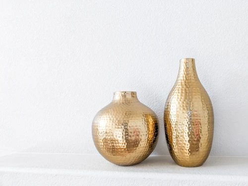Sculptural gold decorative objects arranged on a dark surface