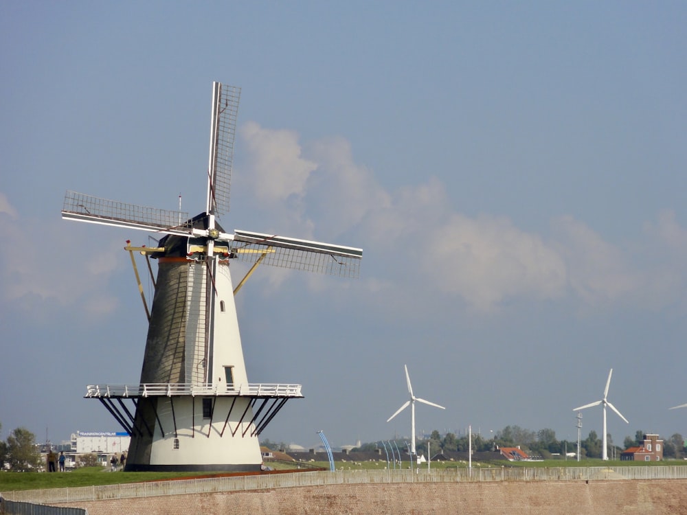 turbina eólica blanca en campo marrón bajo cielo azul durante el día
