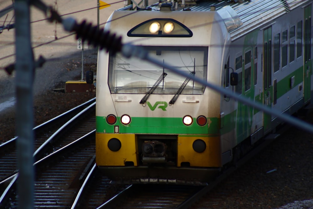 green and white train on rail tracks
