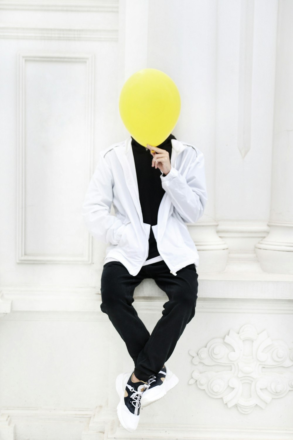 man in white dress shirt holding yellow balloon