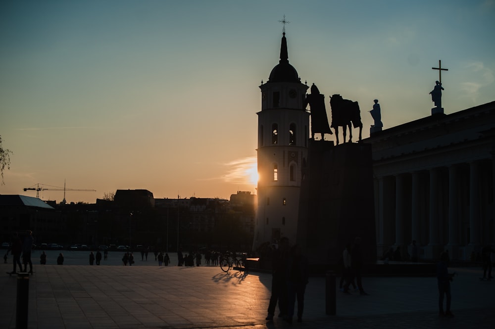 people walking on street near building during sunset