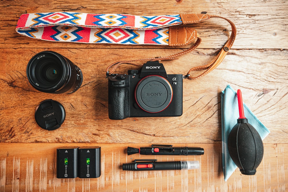 black nikon dslr camera beside black and silver click pen