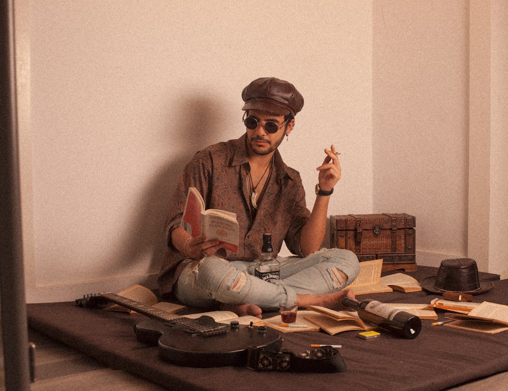 man in brown button up shirt and blue denim jeans sitting on brown wooden table