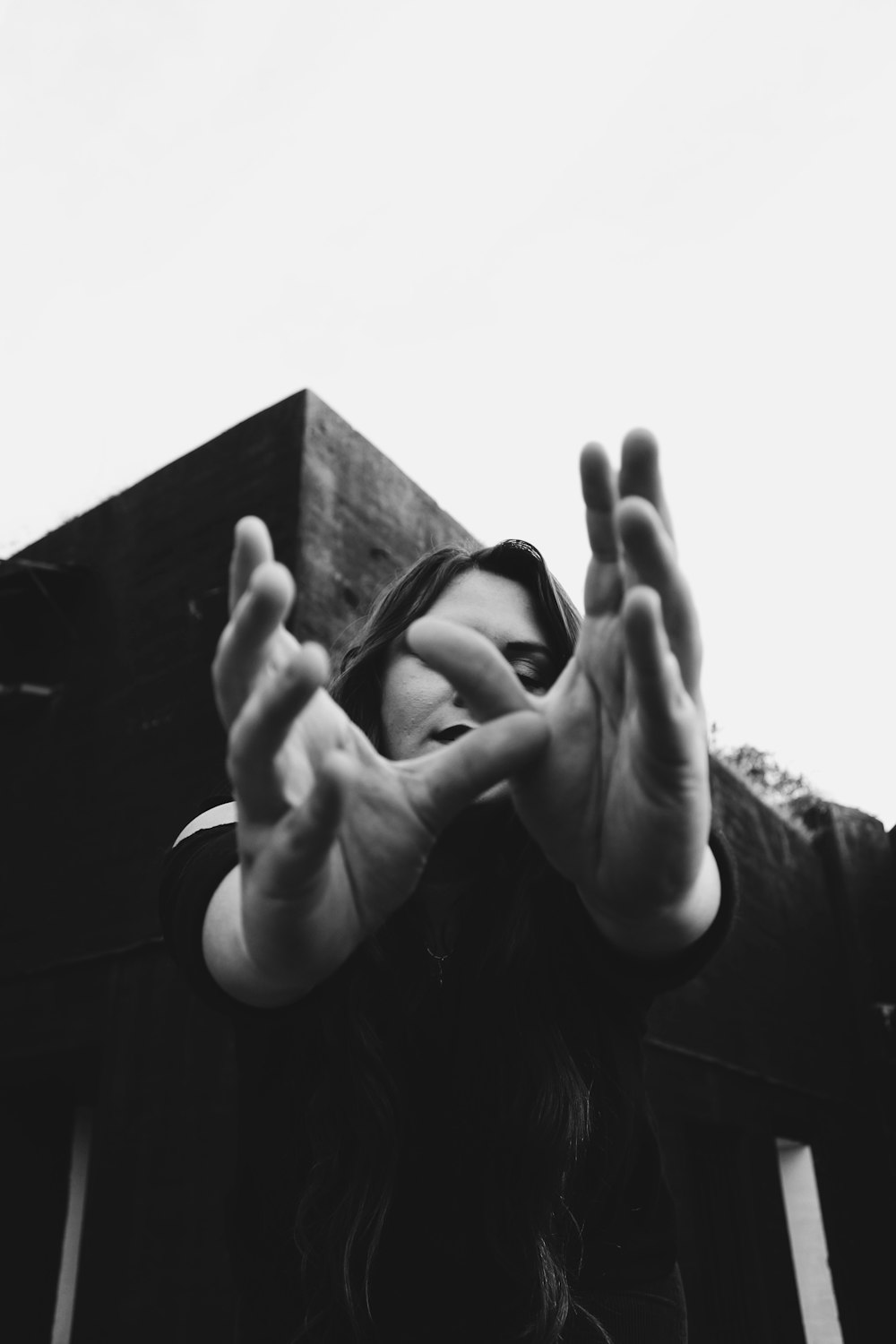 grayscale photo of woman covering her face with her hands