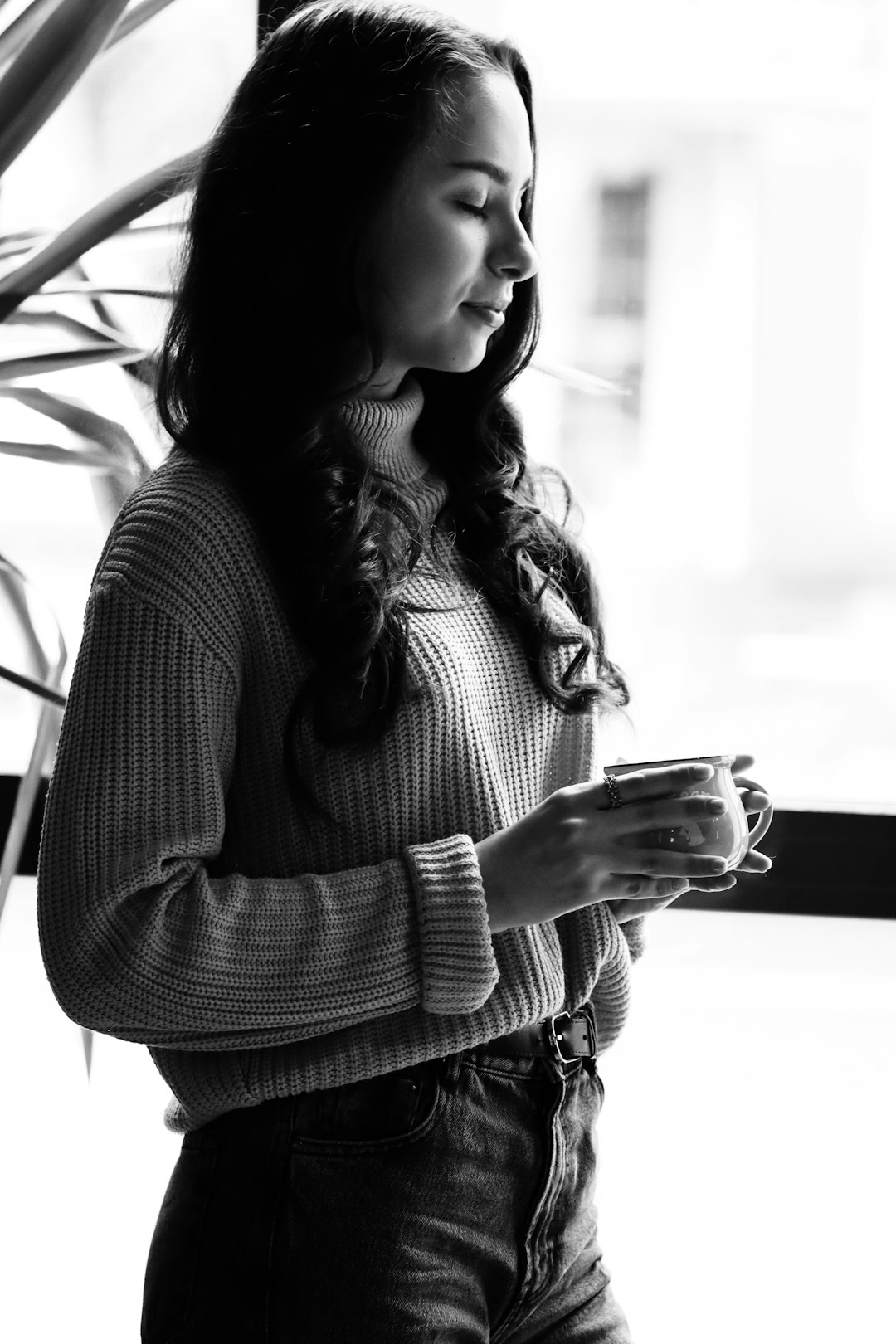 woman in black and white long sleeve shirt holding clear drinking glass